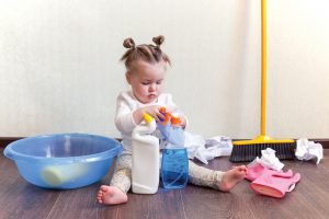 Baby girl playing with chemical bottles